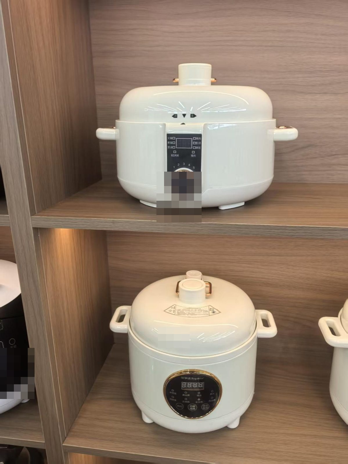 Rice cookers displayed on a showroom shelf at a Chinese appliance factory