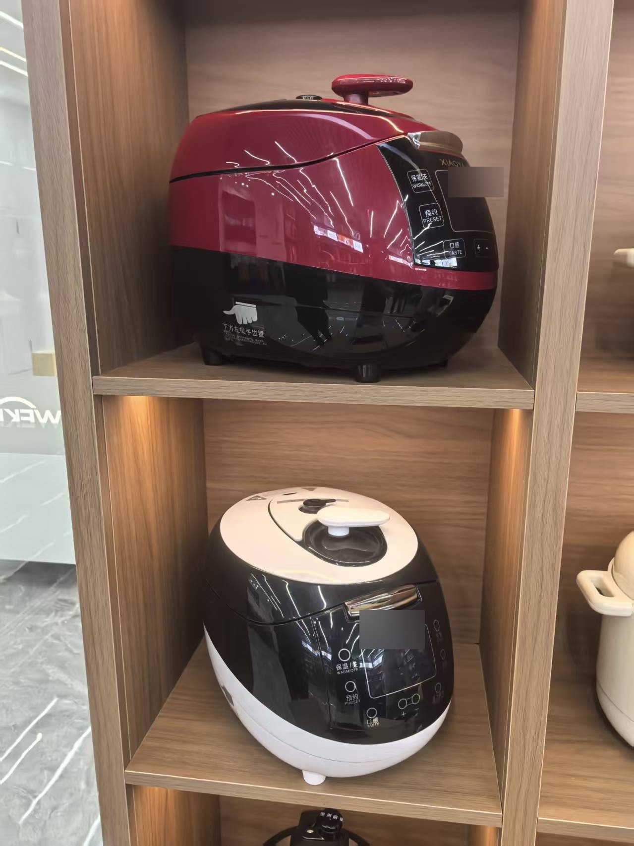 Close-up of electric rice cookers on a showroom shelf
