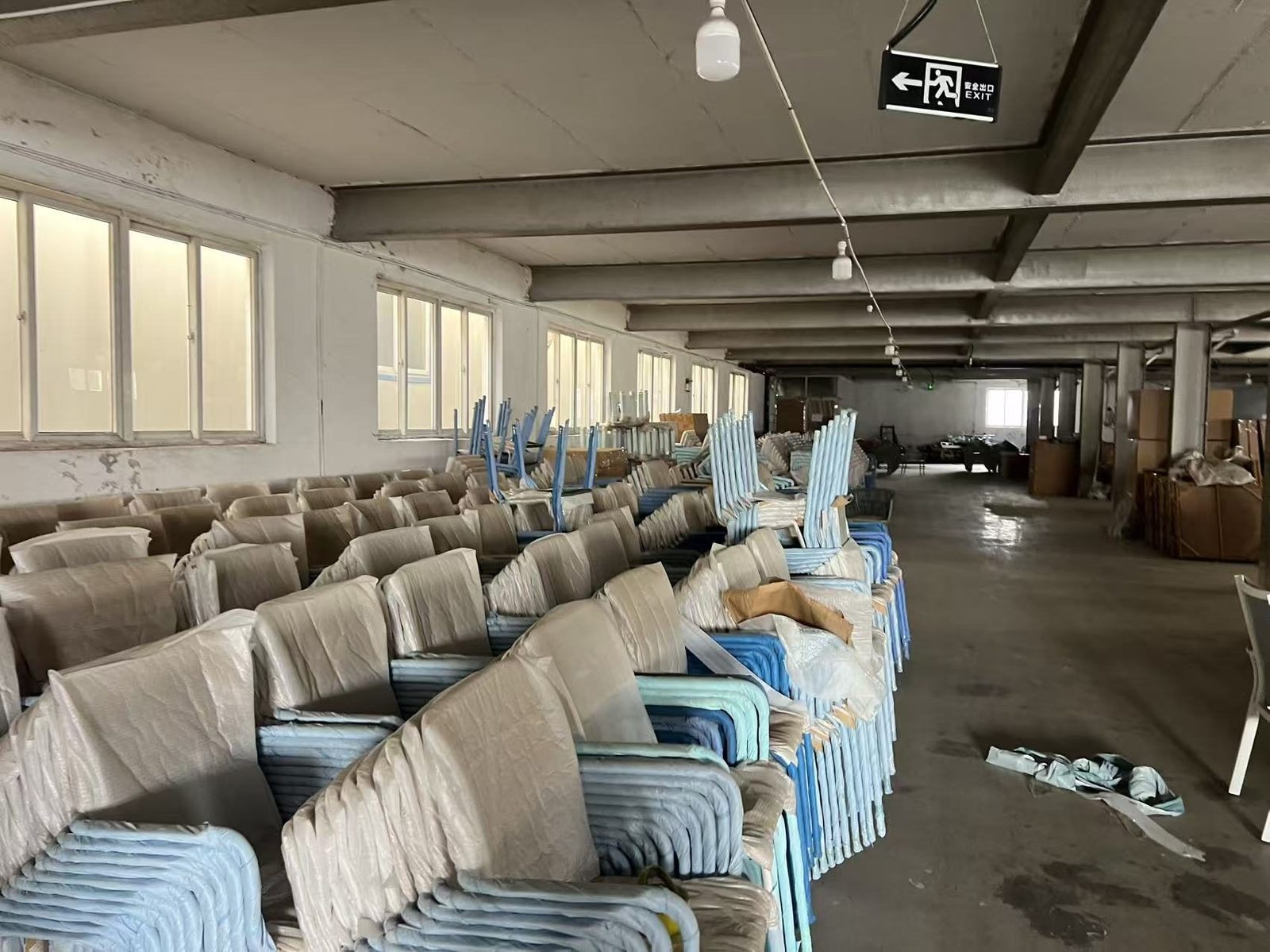 Finished chairs staged and wrapped in a factory warehouse